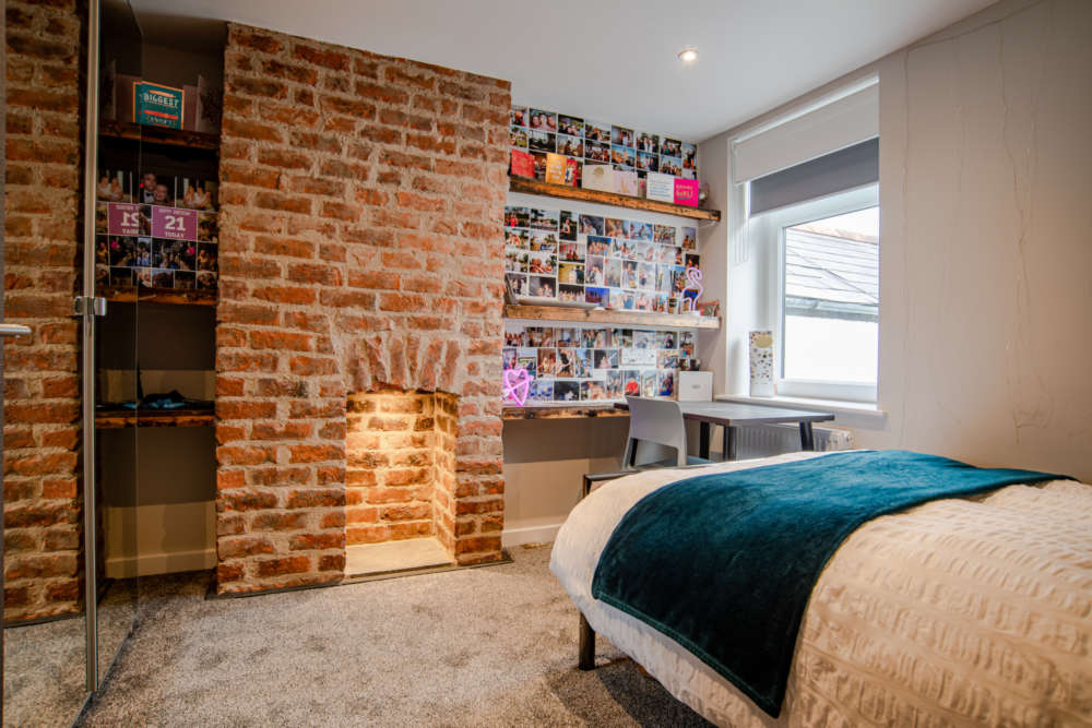Upstairs bedroom with feature chimney breast and lighting