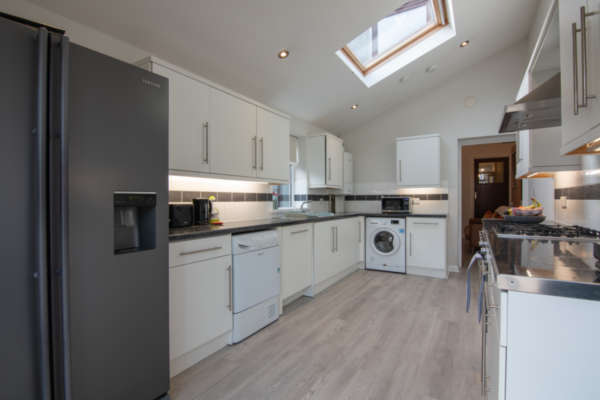 Mod­ern kitchen with Amer­i­can fridge/​freezer and skylights
