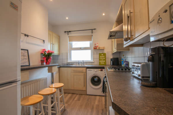 Open-plan kitchen with in-built break­fast bar