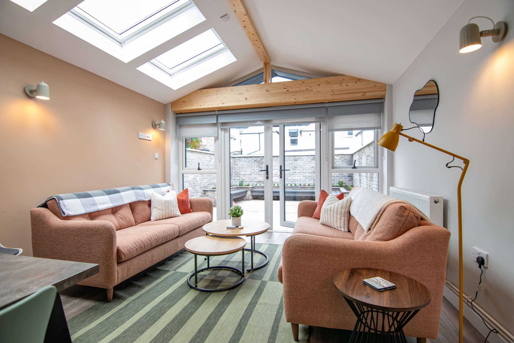 Open-plan living area with electronic skylights and feature beams