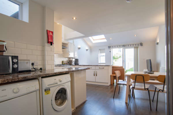 Util­i­ty area and open plan kitchen